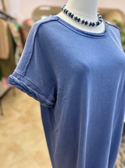 Blue dress with braided sleeve detail on a mannequin in a store setting