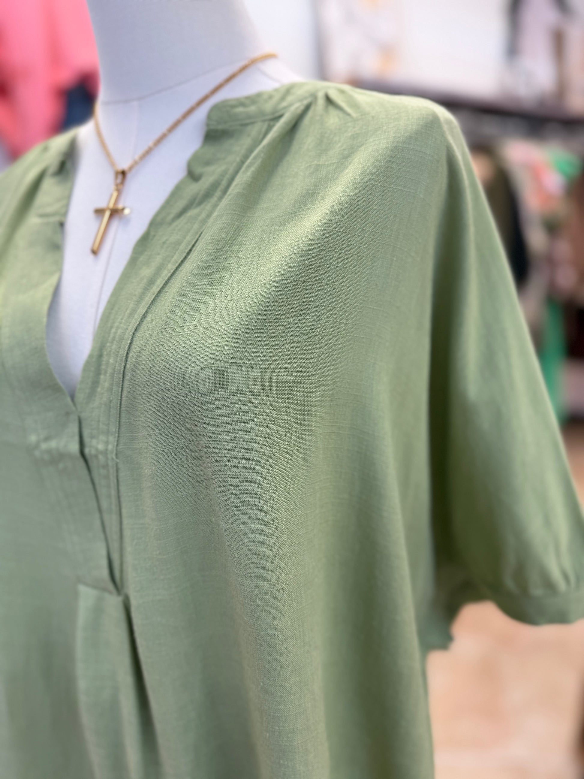 Green blouse on a mannequin with a blurred background
