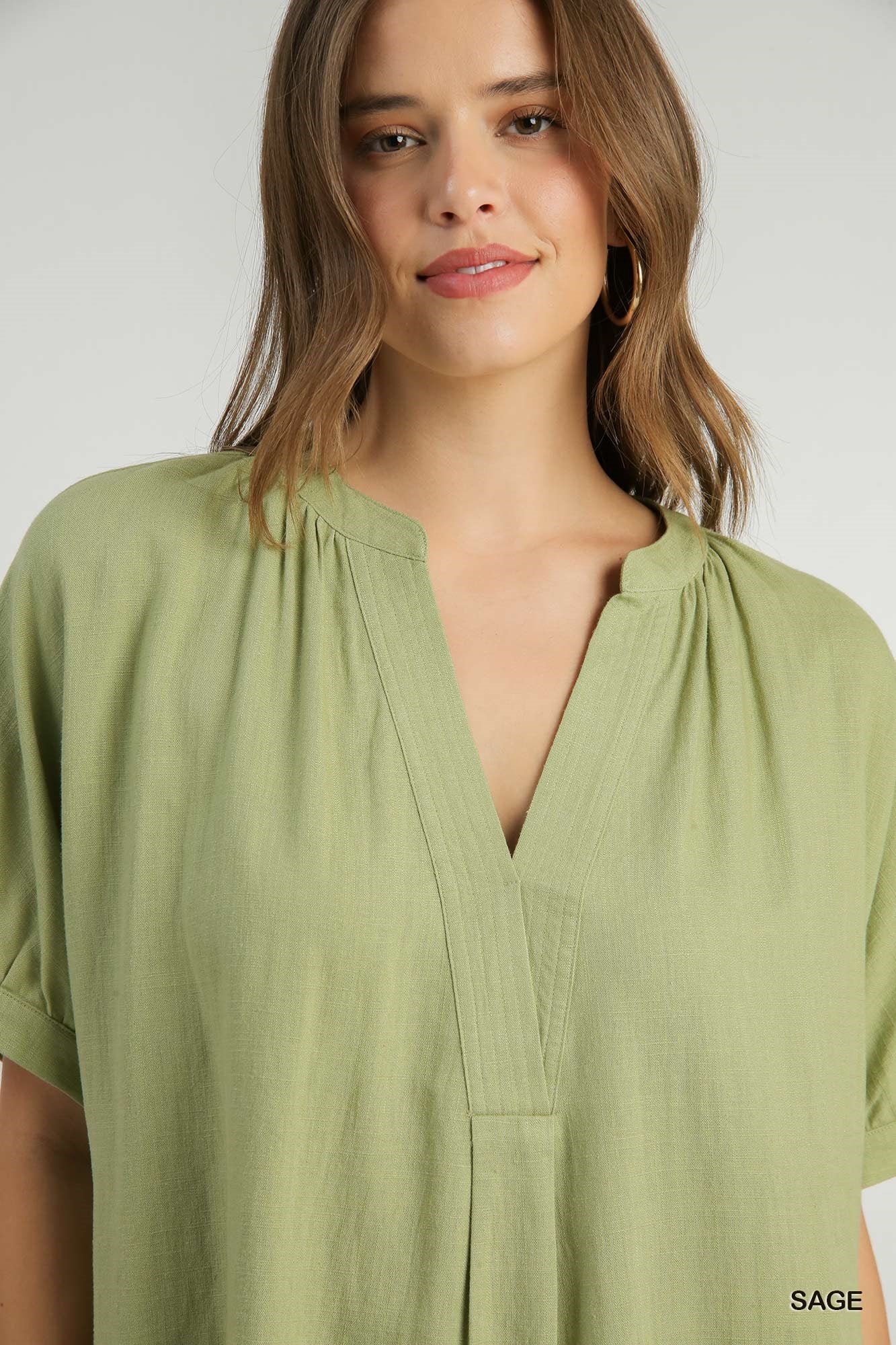Woman wearing a green blouse with a plain background