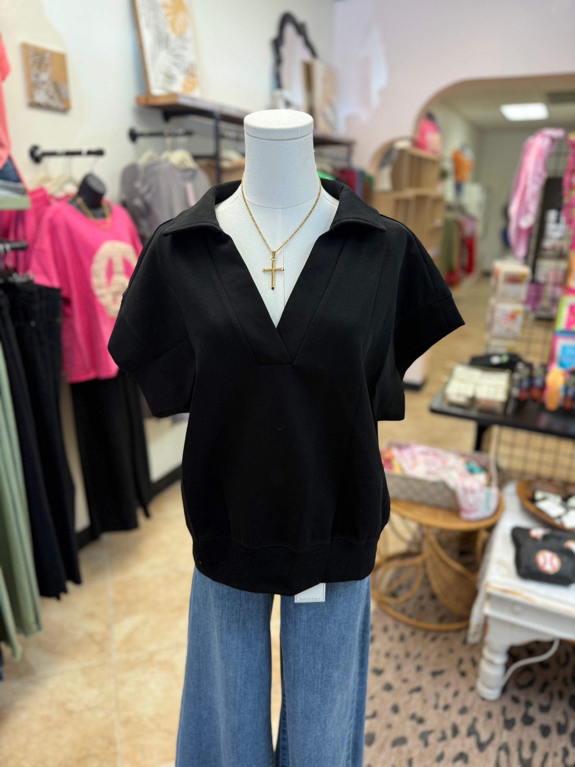 Mannequin wearing a black top and blue jeans in a store setting