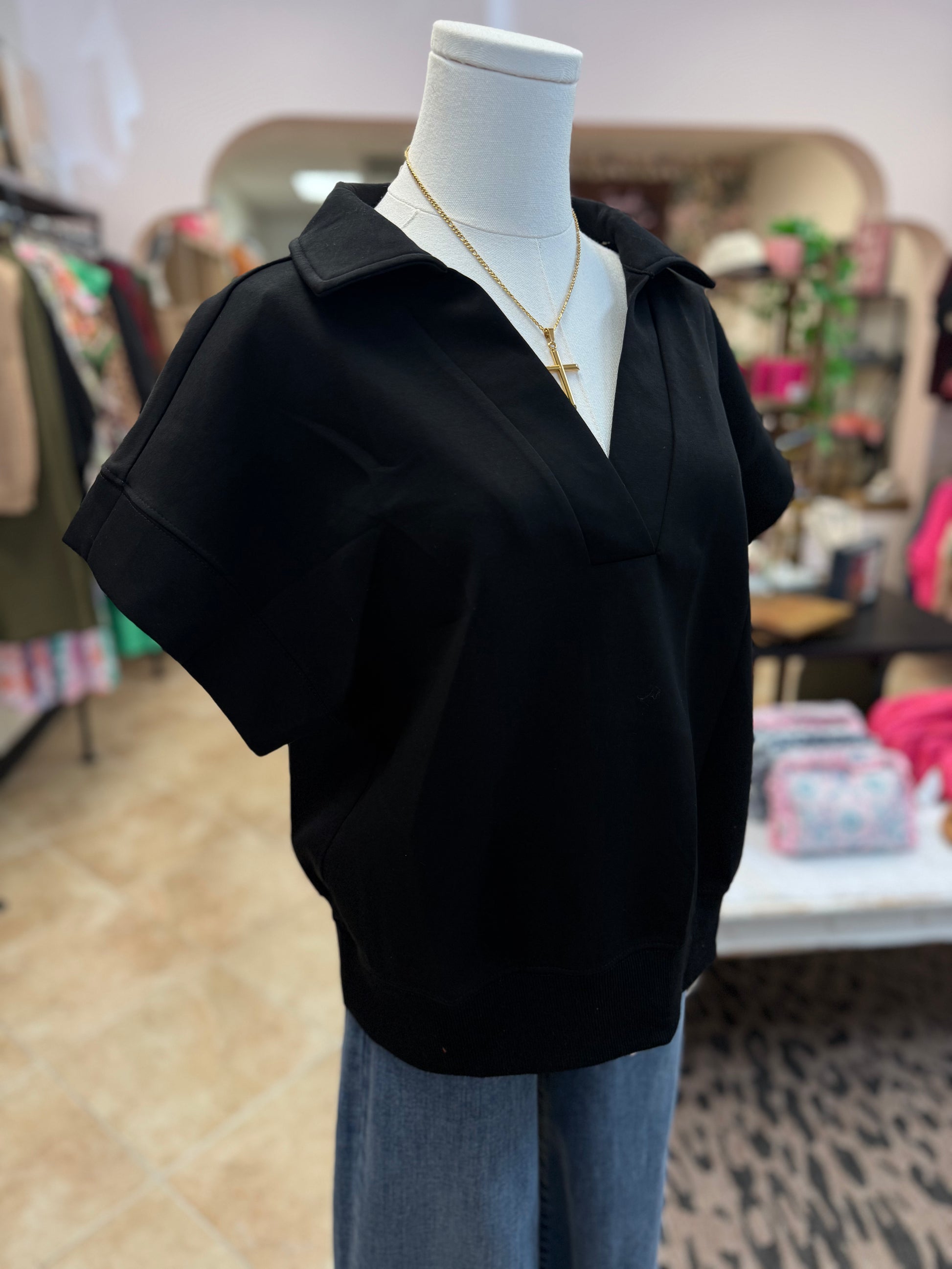 Black blouse on a mannequin with a blurred store interior background
