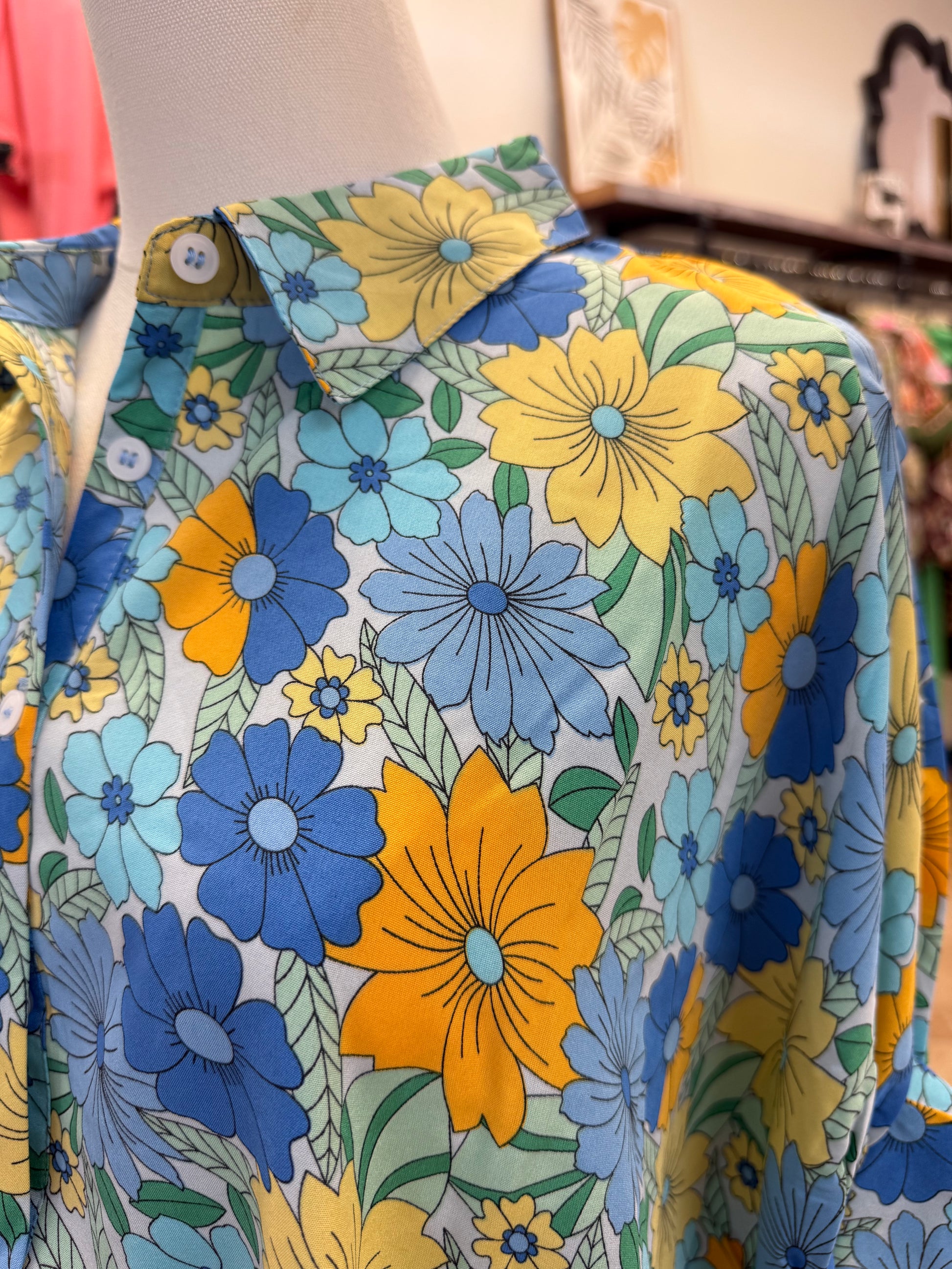 Close up of colorful blue floral button up blouse with collar and jeans