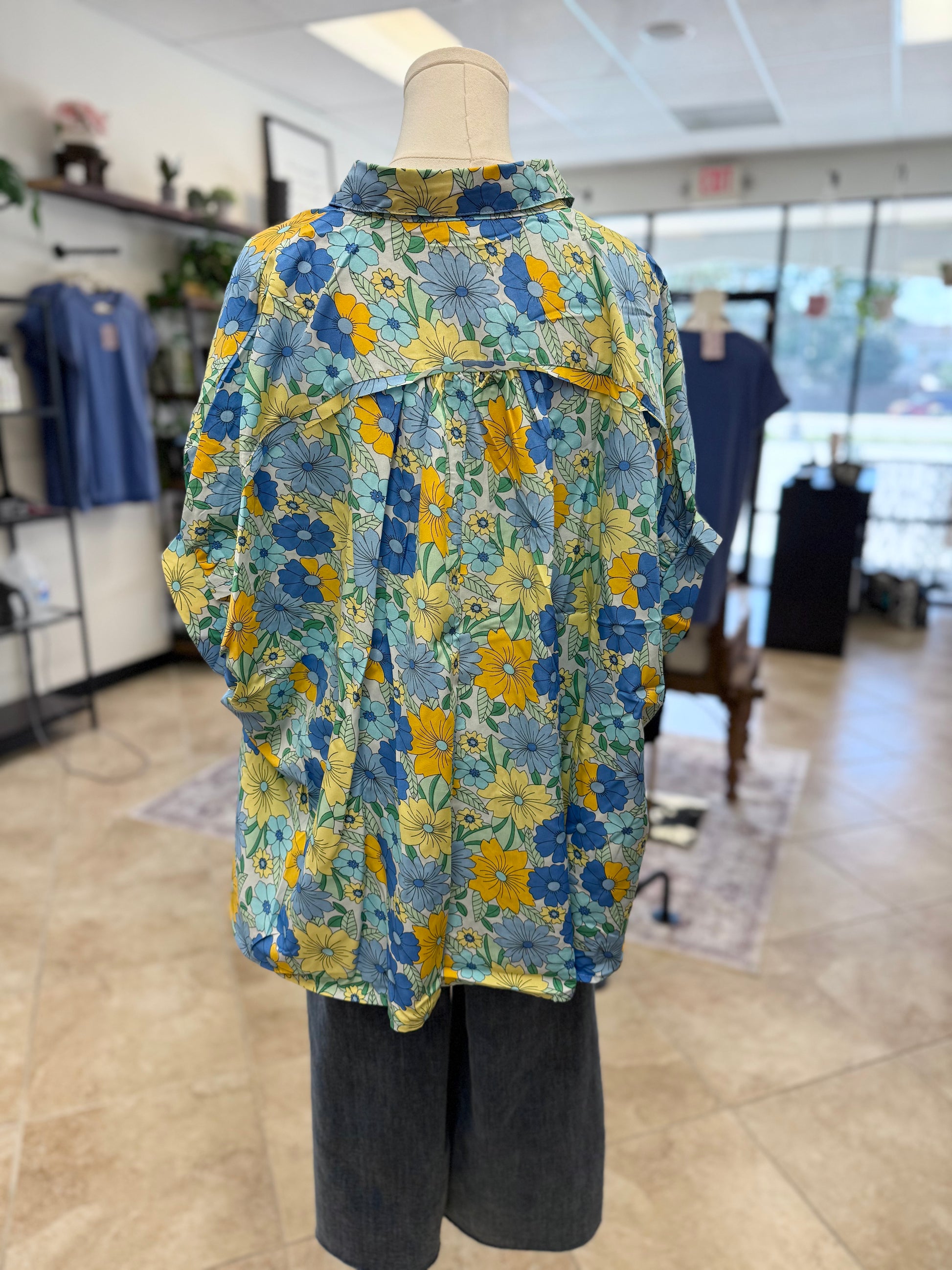 Back of colorful blue floral button up blouse and jeans