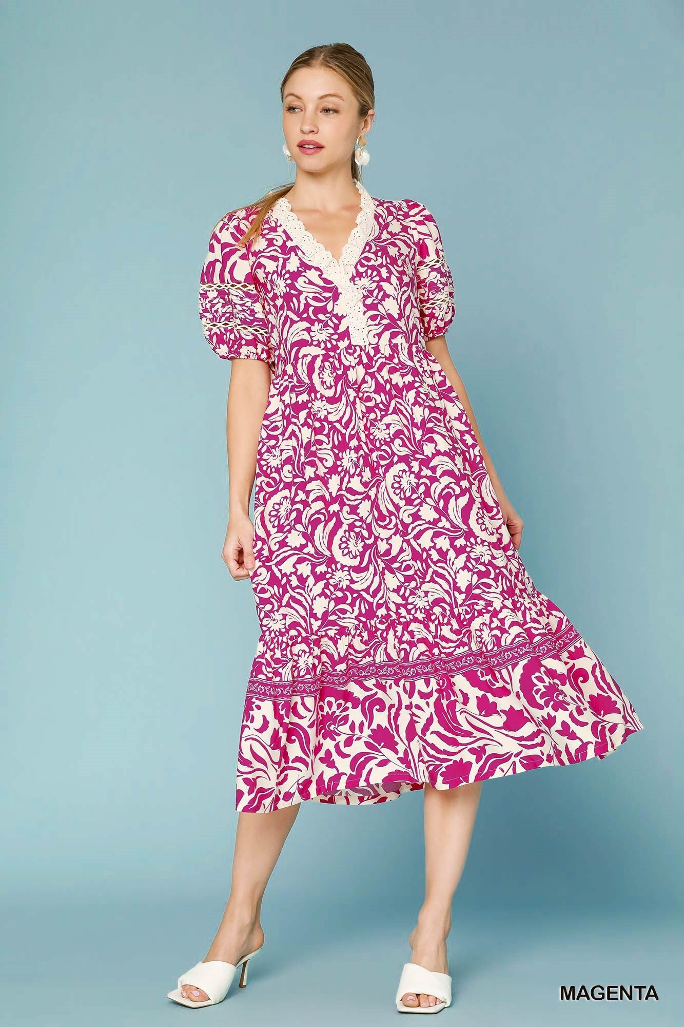 Woman wearing a pink and white patterned dress on a blue background