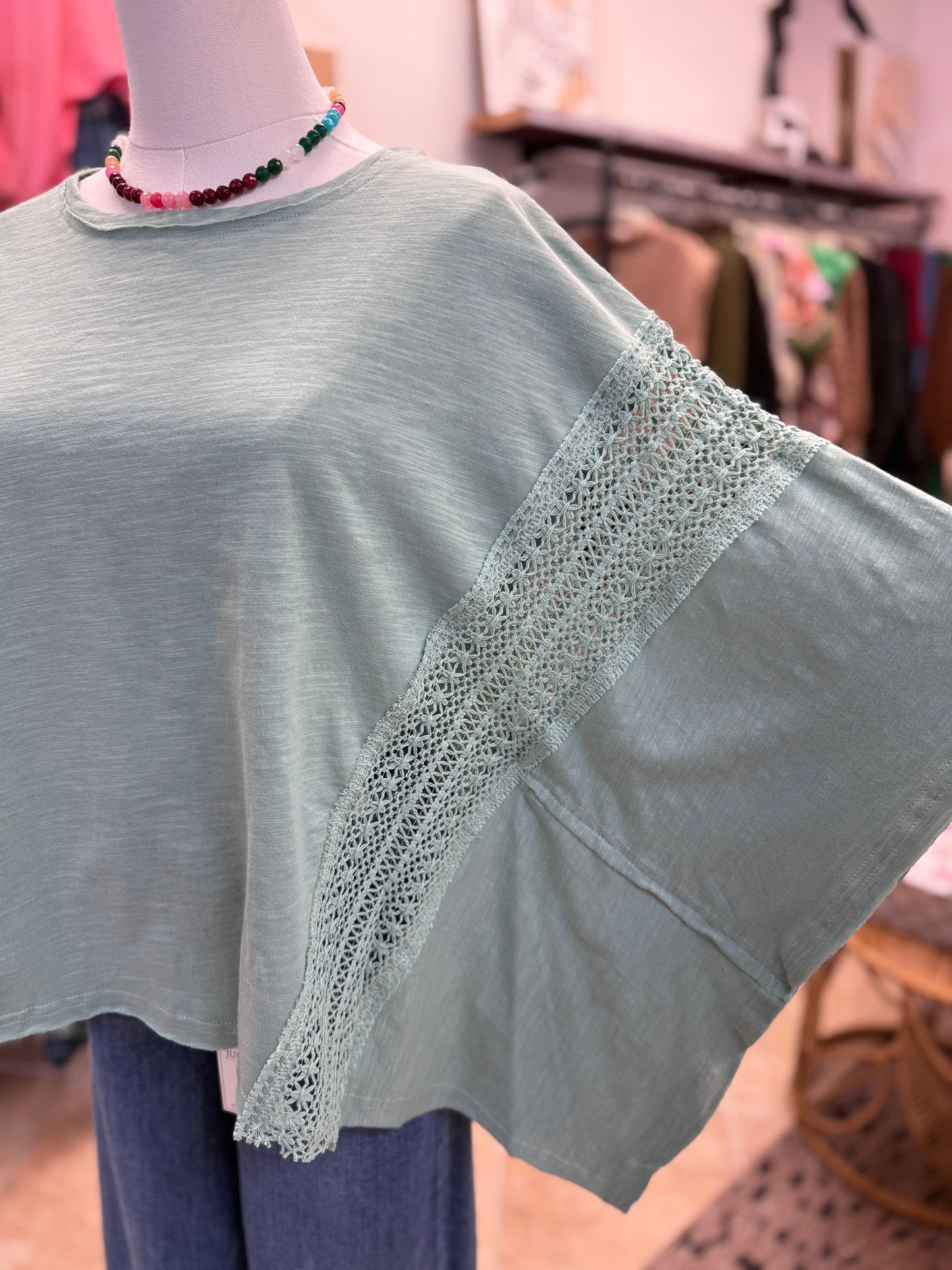 Light green top with lace detail on a mannequin in a store setting